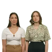 two women standing next to each other with one wearing a white shirt and the other a floral shirt