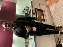 a man holding a bottle of hennessy in a kitchen
