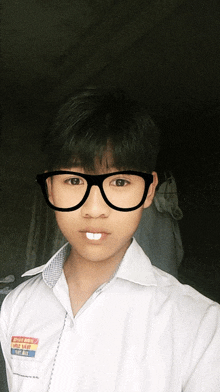 a boy wearing glasses and a shirt that says ' epb ' on the sleeve