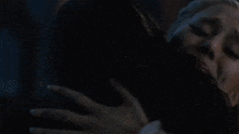 a woman is crying while hugging another woman .