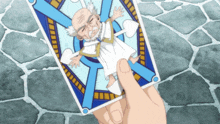 a person is holding a tarot card with a picture of an old man on it