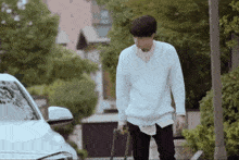 a man in a white sweater carrying a suitcase