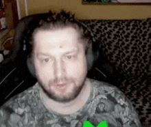 a man with a beard is wearing headphones and a t-shirt with a leopard print