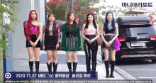 a group of girls are standing in front of a kia vehicle