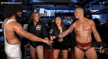 a group of wrestlers are standing in a circle with one wearing a jacket that says nbc on it
