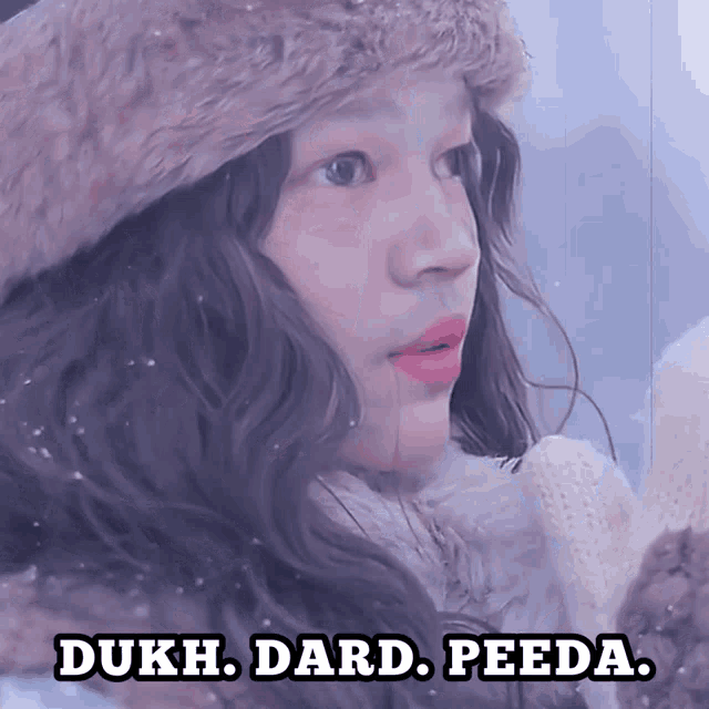 a woman wearing a fur hat and a white sweater with the words dukh dard peeda