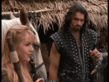 a man and woman are standing next to a white horse