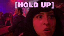 a woman 's face is lit up in red with the words hold up above her