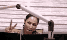 a woman is giving a peace sign while sitting in front of a computer .