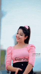 a woman is wearing a pink top with the name elenita on it .
