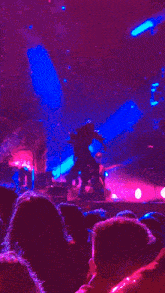 a person is dancing on a stage with purple lights behind them