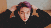 a man with purple hair is wearing a hoodie