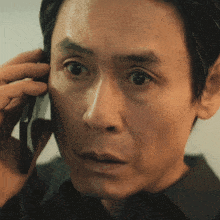 a close up of a man talking on a phone