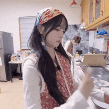 a woman in a kitchen wearing a headband that says ' a ' on it
