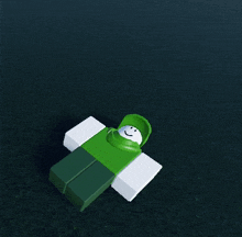 a green roblox character with a white face is laying down
