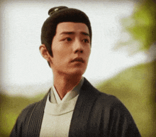 a man with a bun on his head looks to the side