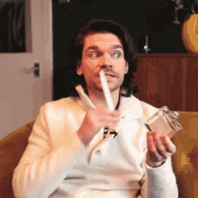 a man in a white sweater is holding a bottle in his hands