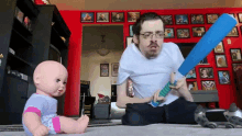 a man playing with a doll and a baseball bat