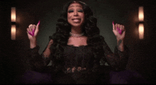 a woman with long pink nails is wearing a black lace top