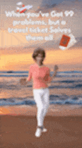 a woman in a pink shirt and white pants is standing on a beach holding a ticket .