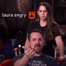 a man and a woman are sitting next to each other and the man is giving the middle finger .