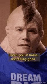 a man with a mohawk wearing a blue shirt that says dream