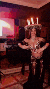 a woman in a belly dancer costume with candles on her hat