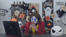 a man in a clown costume looks at a laptop