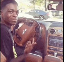a man is sitting in a bentley car and giving the middle finger