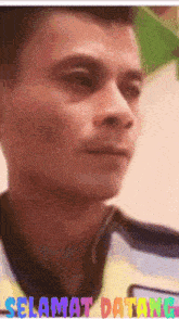 a close up of a man 's face with the words " selamat datang " below him