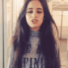 a woman with long dark hair is wearing a sweater that says " be a fin "