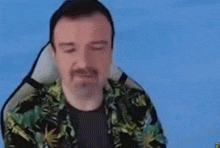 a man with a beard is sitting in a chair with his eyes closed and his mouth open .