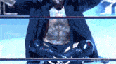 a man with a tattoo on his chest is sitting in a boxing ring with the words live on the bottom