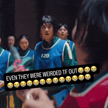 a group of people are standing in a room and one of them has the number 120 on their shirt