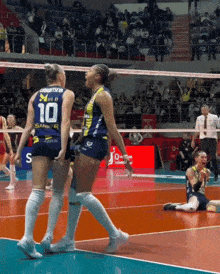 two female volleyball players one with the number 10 on their jersey