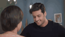 a man and a woman are looking at each other and the man is smiling