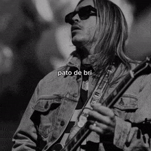 a black and white photo of a man playing a guitar with the name pato de bri written below him