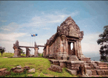 a very old stone building with a few flags in front of it