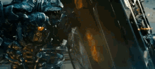 a robot is fighting another robot with a laser beam coming out of it .