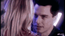 a man and a woman are looking at each other and kissing .