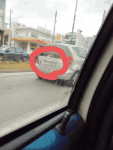 a silver car with a license plate that says pk 2082 is driving down the road