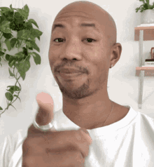a bald man with a beard wearing a ring on his finger