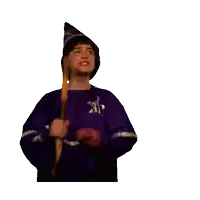 a boy in a wizard costume holds a wand in his hand