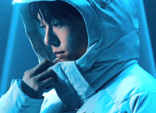 a man wearing a white jacket with a hood that says ' waterproof ' on the front