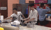 two men are cooking in a kitchen with a sign that says occupied on it