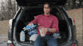 a man is sitting in the back of a car holding a glass and a bottle of diet pepsi