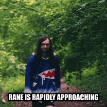 a man in a blue shark sweater is walking through the woods with the caption rane is rapidly approaching