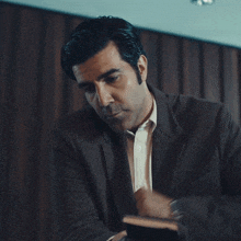 a man in a suit is giving a thank you for your help sign