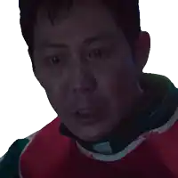 a close up of a man 's face with a red and green shirt on