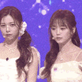 a couple of women standing next to each other with a purple background